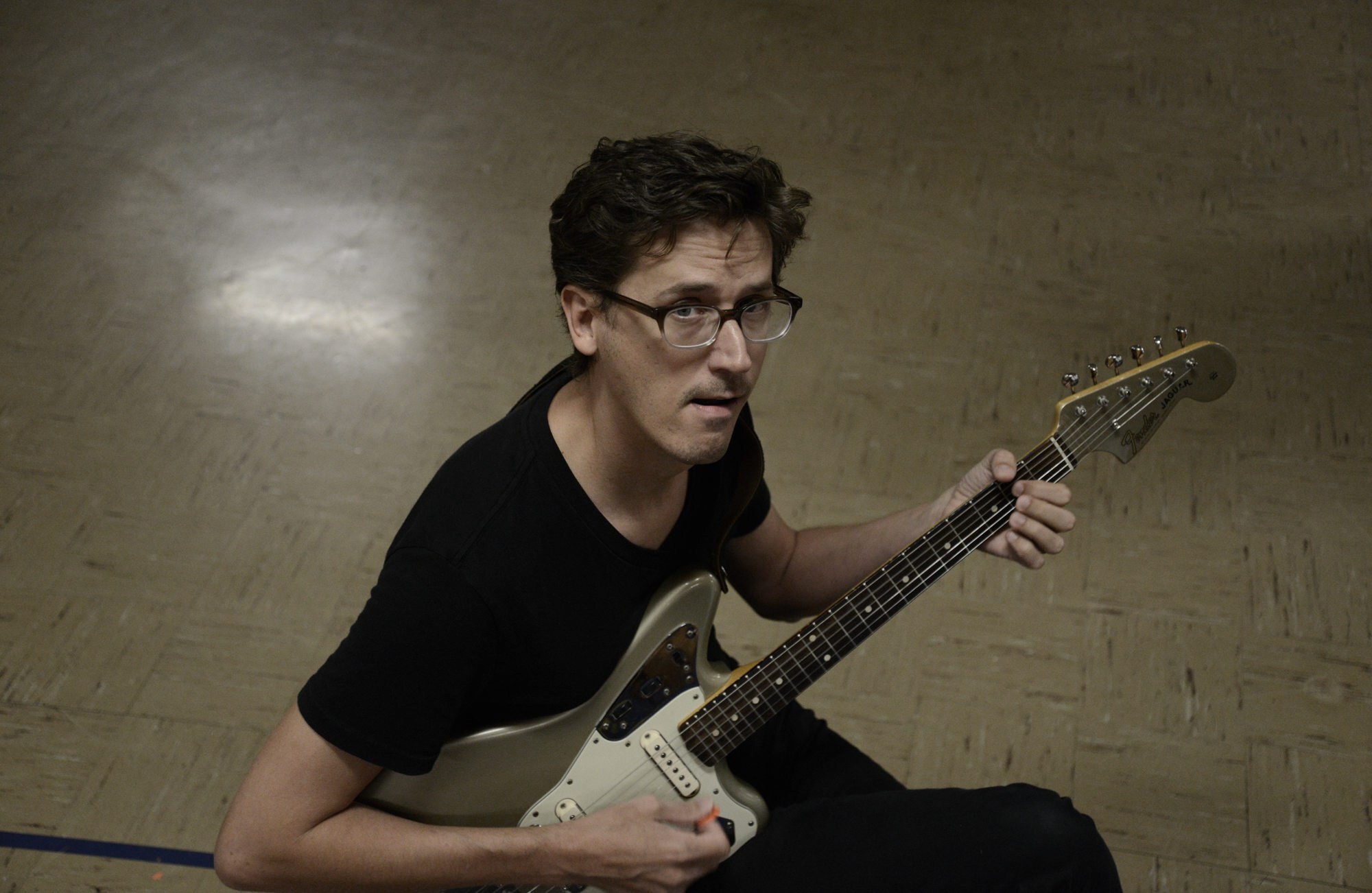 Don Cento plays guitar in a cafeteria.